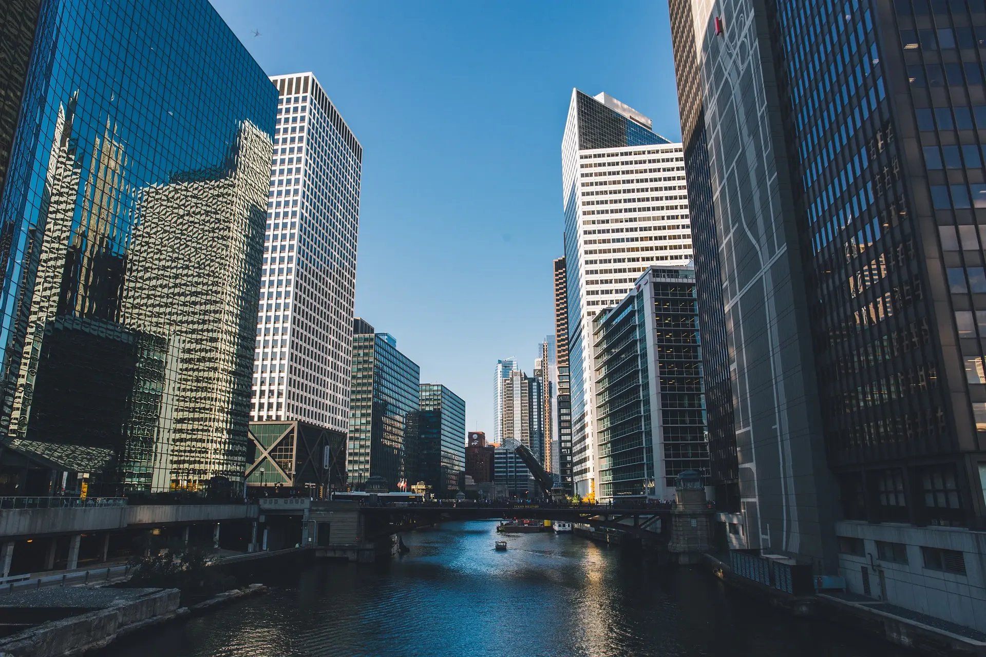 City office towers along a river under a blue sky